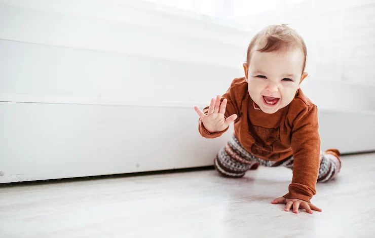 happy child orange sweater plays with feather floor 8353 185