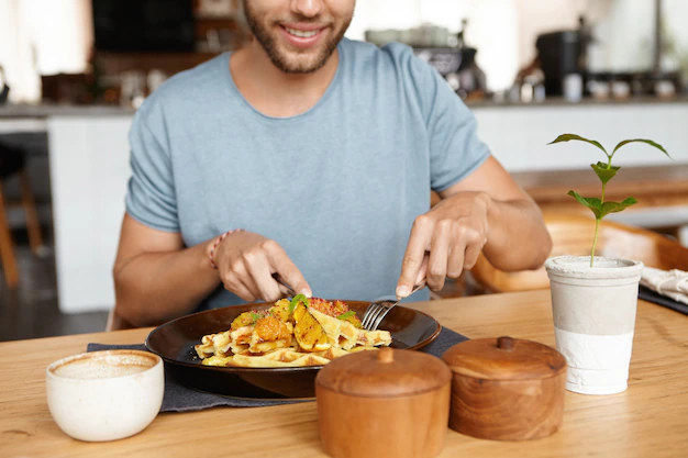 cropped portrait happy young bearded male t shirt smiling cheerfully while enjoying tasty meal during lunch cozy restaurant sitting wooden table 273609 1965