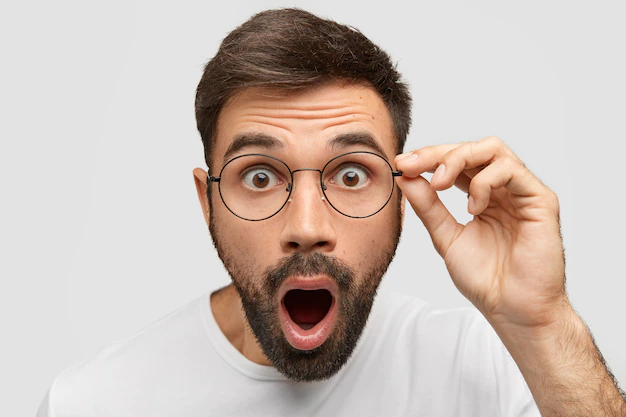 close up portrait stunned bearded young guy drops jaw has bugged dark eyes sees something unbelievable surprising has eyewear isolated white wall people emotions concept 273609 15474
